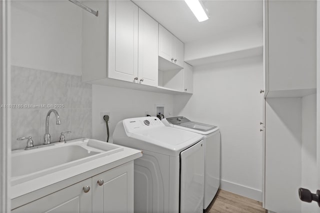 477 Spinnaker, Weston, FL 33326 - washroom featuring cabinet space, washer and dryer, light wood-type flooring, and baseboards