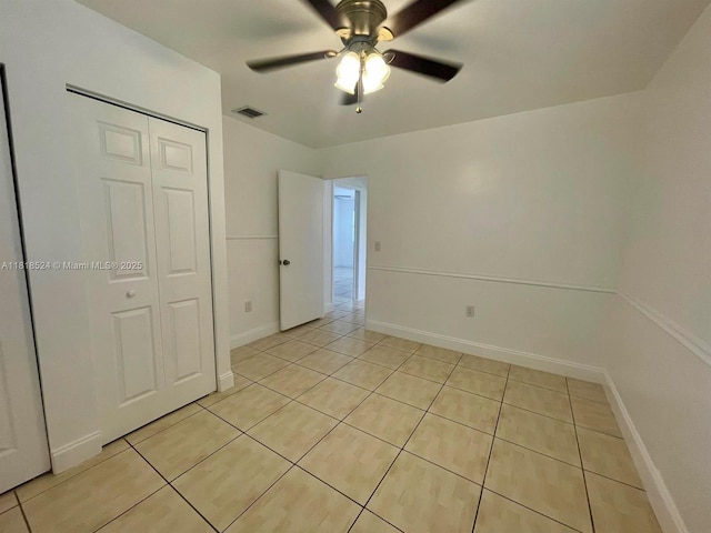 4562 Old Military Trl, West Palm Beach, FL 33417 - unfurnished bedroom featuring light tile patterned floors, a closet, ceiling fan, and baseboards