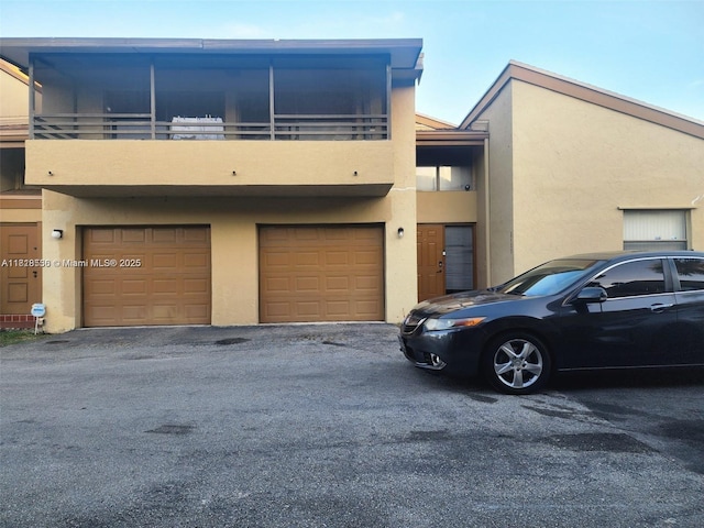 8409 N Missionwood Cir Unit D-30, Miramar, FL 33025 - view of property with a garage, stucco siding, and asphalt driveway