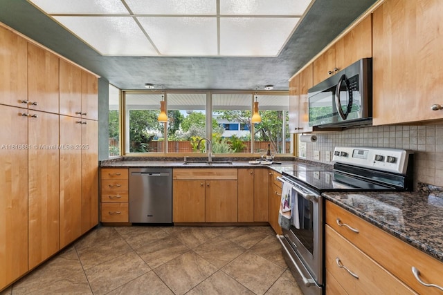 1305 N 47th Ave, Hollywood, FL 33021 - kitchen with appliances with stainless steel finishes, tasteful backsplash, dark stone counters, and brown cabinets