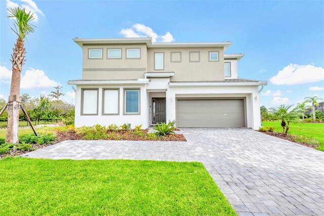 2496 Rama Dr, Kissimmee, FL 34746 - prairie-style house with stucco siding, a garage, a front lawn, and decorative driveway
