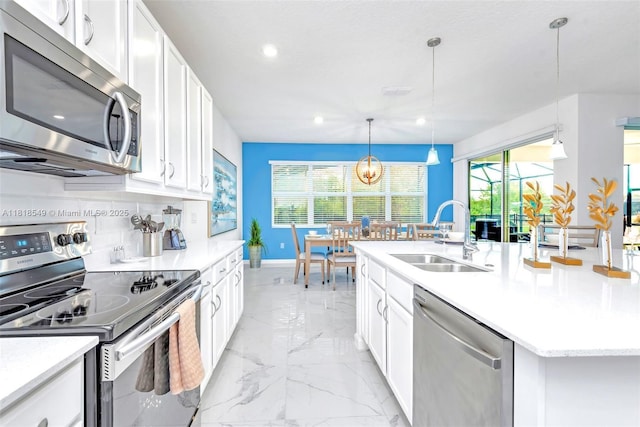 2496 Rama Dr, Kissimmee, FL 34746 - kitchen featuring appliances with stainless steel finishes, light marble finish flooring, an island with sink, white cabinetry, and recessed lighting