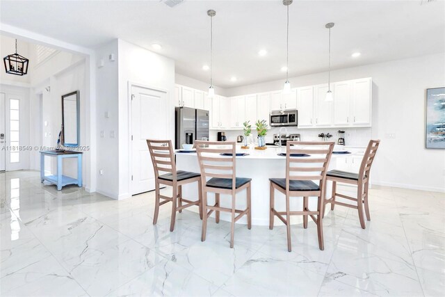 2496 Rama Dr, Kissimmee, FL 34746 - kitchen with stainless steel appliances, a breakfast bar, light marble finish floors, white cabinetry, and recessed lighting