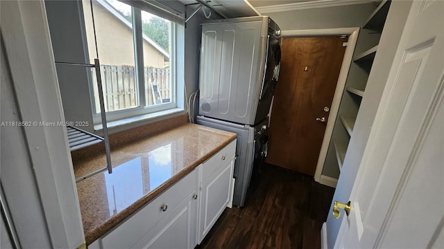 9480 NW 10th St, Plantation, FL 33322 - washroom featuring stacked washer and clothes dryer, dark wood finished floors, cabinet space, and ornamental molding