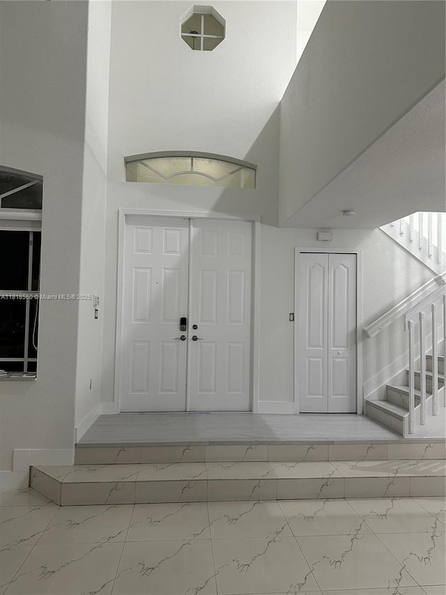 16650 SW 61st Ln, Miami, FL 33193 - foyer entrance with marble look tiles, stairway, and a towering ceiling