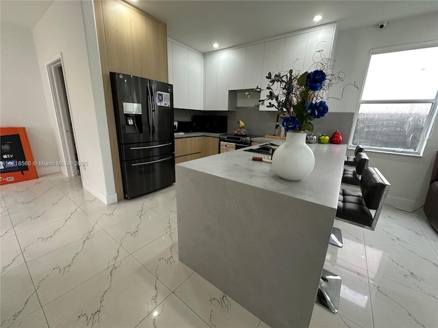 16650 SW 61st Ln, Miami, FL 33193 - kitchen with black refrigerator with ice dispenser, a peninsula, light marble finish floors, stainless steel range with electric cooktop, and modern cabinets