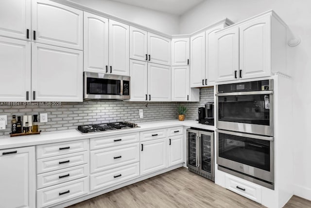 11400 NW 27th St, Plantation, FL 33323 - kitchen featuring stainless steel appliances, wine cooler, tasteful backsplash, and white cabinets
