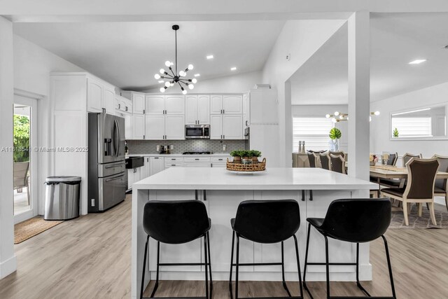 11400 NW 27th St, Plantation, FL 33323 - kitchen with a chandelier, stainless steel appliances, light countertops, white cabinets, and vaulted ceiling