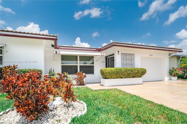 5803 NW 85th Ter, Tamarac, FL 33321 - view of front of home with an attached garage, a tiled roof, concrete driveway, and stucco siding