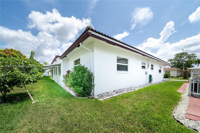 5803 NW 85th Ter, Tamarac, FL 33321 - view of property exterior featuring stucco siding, a yard, and a tile roof