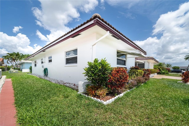 5803 NW 85th Ter, Tamarac, FL 33321 - view of side of home with a tile roof, a yard, and stucco siding