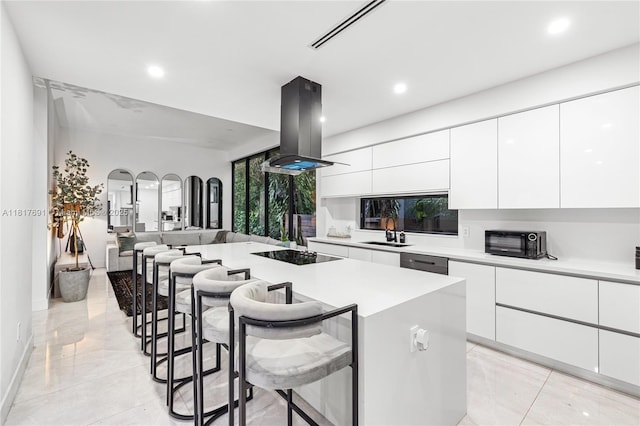 3660 SW 12th St, Miami, FL 33135 - kitchen with modern cabinets, black electric cooktop, recessed lighting, a breakfast bar, and island exhaust hood