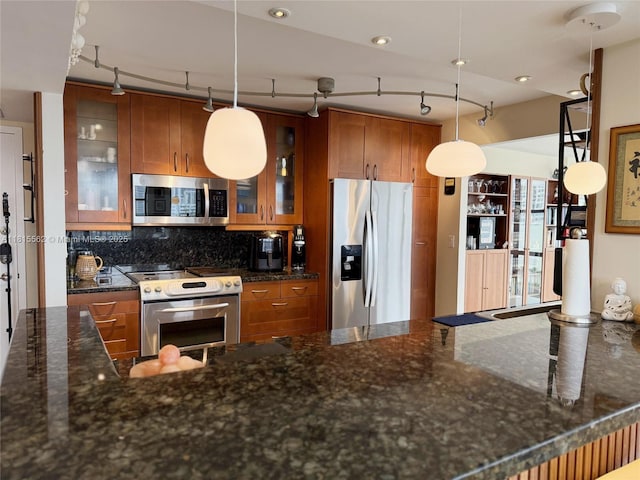 800 Parkview Dr Unit 820, Hallandale Beach, FL 33009 - kitchen with stainless steel appliances, brown cabinetry, track lighting, and tasteful backsplash
