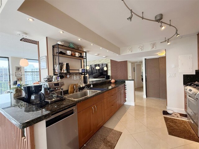 800 Parkview Dr Unit 820, Hallandale Beach, FL 33009 - kitchen with stainless steel appliances, a sink, brown cabinets, light tile patterned floors, and baseboards