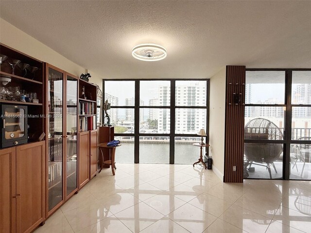 800 Parkview Dr Unit 820, Hallandale Beach, FL 33009 - empty room with a wall of windows, healthy amount of natural light, light tile patterned floors, a textured ceiling, and a city view