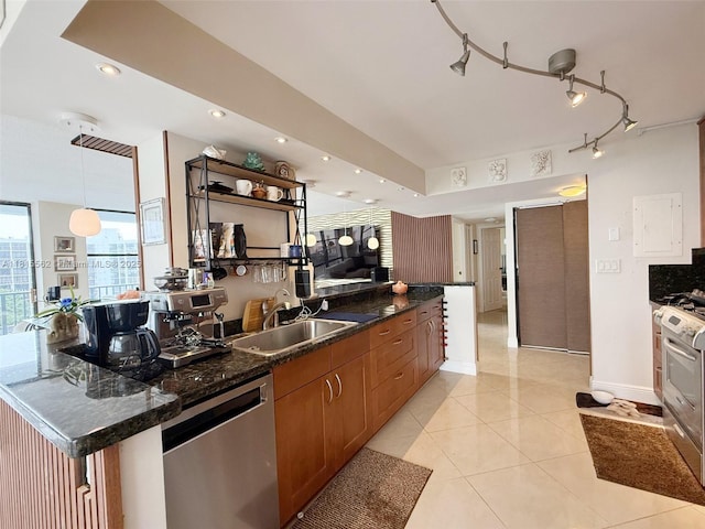 800 Parkview Dr Unit 820, Hallandale Beach, FL 33009 - kitchen featuring appliances with stainless steel finishes, a sink, brown cabinets, light tile patterned floors, and baseboards