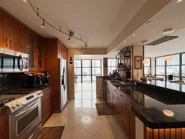 800 Parkview Dr Unit 820, Hallandale Beach, FL 33009 - kitchen with stainless steel appliances, light tile patterned floors, glass insert cabinets, dark stone counters, and decorative light fixtures