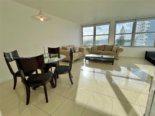 2899 Collins Ave Unit 810, Miami Beach, FL 33140 - dining area featuring light tile patterned floors, baseboards, and vaulted ceiling