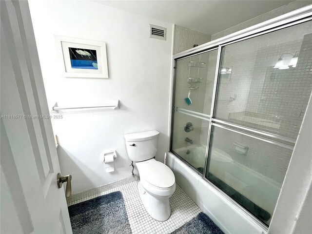 2899 Collins Ave Unit 810, Miami Beach, FL 33140 - full bathroom featuring toilet, tile patterned floors, and bath / shower combo with glass door