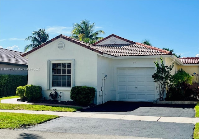 886 SW 180th Ter, Pembroke Pines, FL 33029 - mediterranean / spanish-style home with an attached garage, asphalt driveway, stucco siding, and a tiled roof