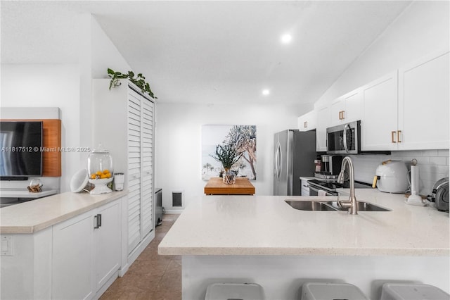 886 SW 180th Ter, Pembroke Pines, FL 33029 - kitchen with a peninsula, stainless steel appliances, light stone counters, white cabinets, and backsplash