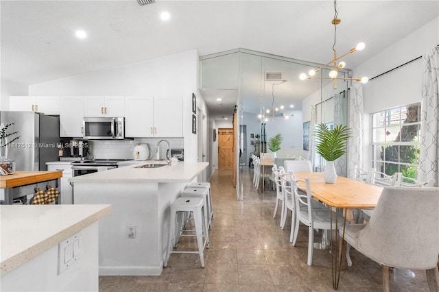 886 SW 180th Ter, Pembroke Pines, FL 33029 - kitchen featuring stainless steel appliances, white cabinetry, light countertops, backsplash, and hanging light fixtures