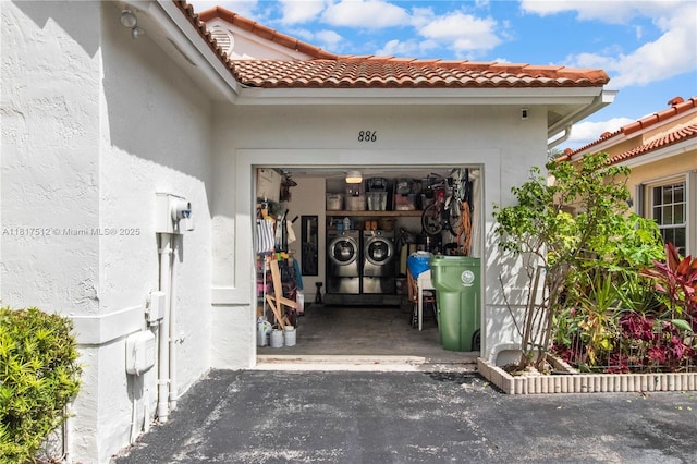 886 SW 180th Ter, Pembroke Pines, FL 33029 - entrance to property featuring washer and clothes dryer, stucco siding, and a tile roof