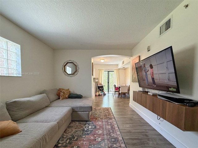 22901 SW 88th Pl Unit 101, Cutler Bay, FL 33190 - living area with arched walkways, a textured ceiling, and dark wood-type flooring