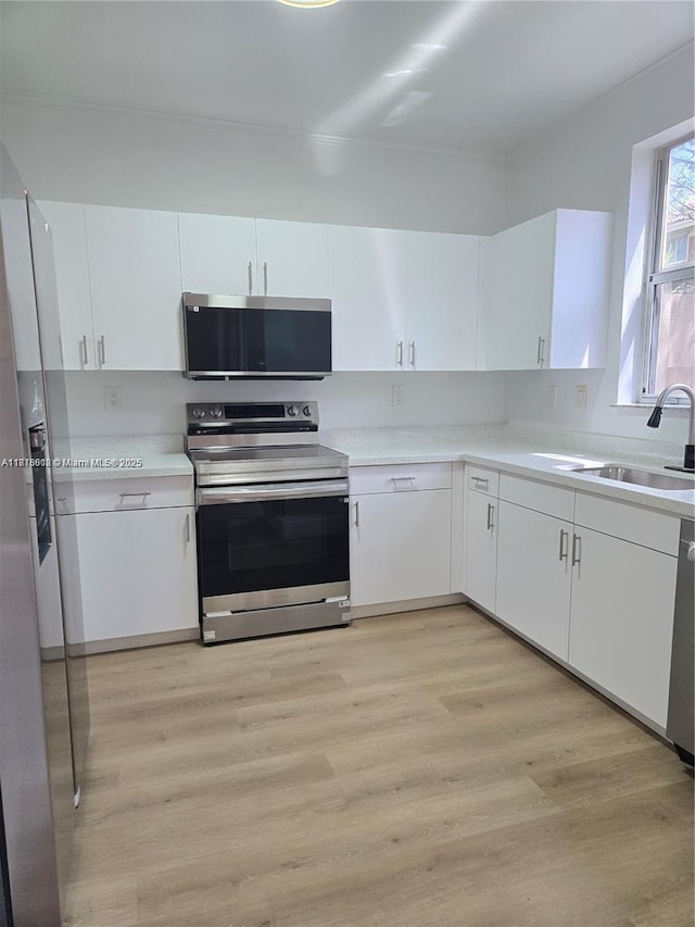 129 Riverwalk Cir Unit 129, Sunrise, FL 33326 - kitchen with appliances with stainless steel finishes, light wood-type flooring, light countertops, and white cabinetry