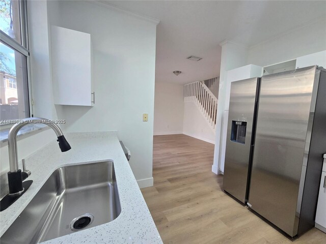 129 Riverwalk Cir Unit 129, Sunrise, FL 33326 - kitchen with stainless steel fridge, a sink, light wood-type flooring, and white cabinetry
