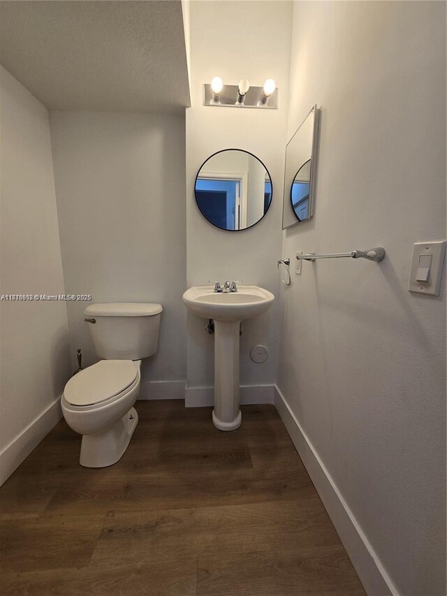 129 Riverwalk Cir Unit 129, Sunrise, FL 33326 - half bath with wood finished floors, baseboards, toilet, and a sink