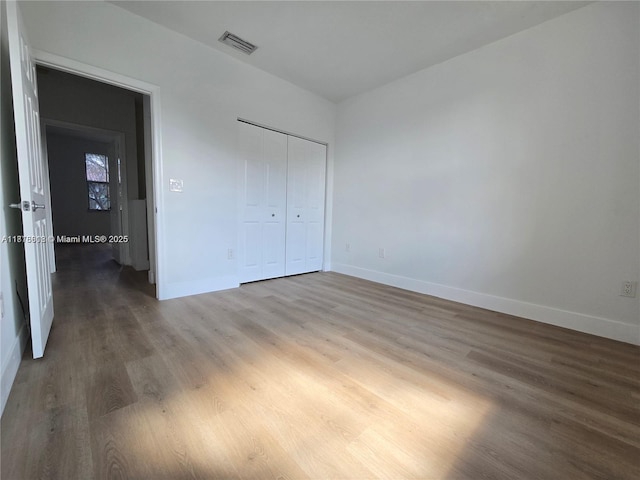 129 Riverwalk Cir Unit 129, Sunrise, FL 33326 - unfurnished bedroom featuring wood finished floors, baseboards, and a closet