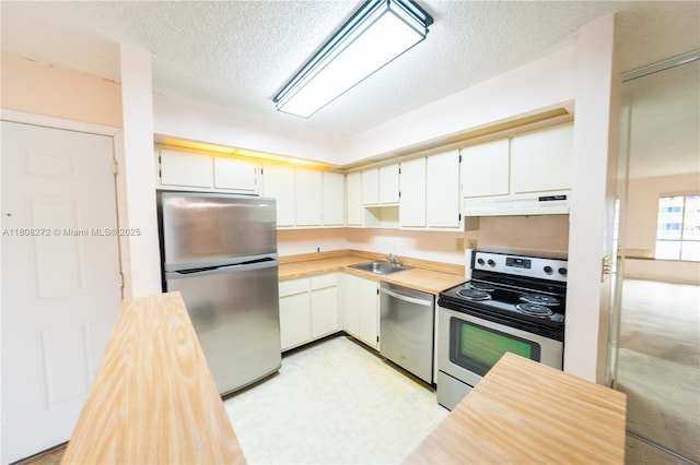 18785 NW 62nd Ave Unit 106, Hialeah, FL 33015 - kitchen with appliances with stainless steel finishes, under cabinet range hood, a textured ceiling, and white cabinets