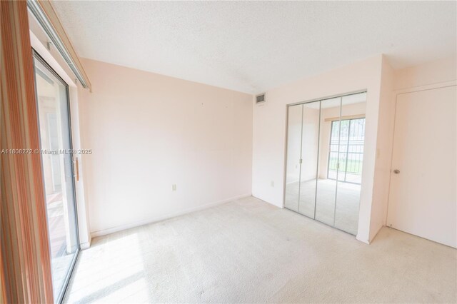 18785 NW 62nd Ave Unit 106, Hialeah, FL 33015 - unfurnished bedroom with light carpet, a closet, and a textured ceiling