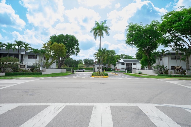 18785 NW 62nd Ave Unit 106, Hialeah, FL 33015 - view of asphalt road with a residential view, sidewalks, a gate, and curbs