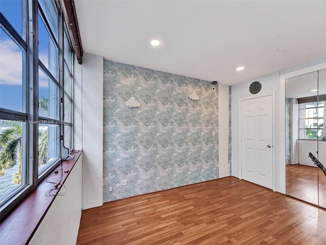 1408 Brickell Bay Dr Unit 411, Miami, FL 33131 - empty room with wallpapered walls, an accent wall, wood finished floors, and recessed lighting