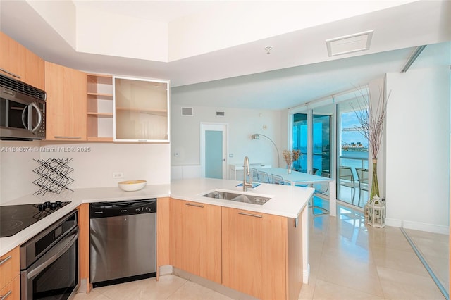 480 NE 30th St Unit 1505, Miami, FL 33137 - kitchen featuring stainless steel appliances, a peninsula, light brown cabinets, and light countertops