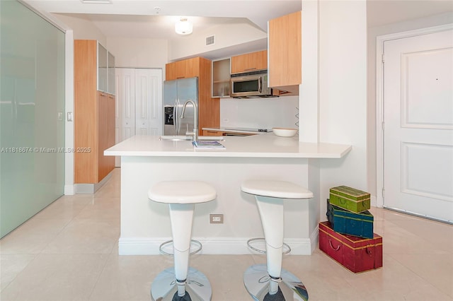 480 NE 30th St Unit 1505, Miami, FL 33137 - kitchen featuring stainless steel appliances, light countertops, a peninsula, a breakfast bar area, and modern cabinets