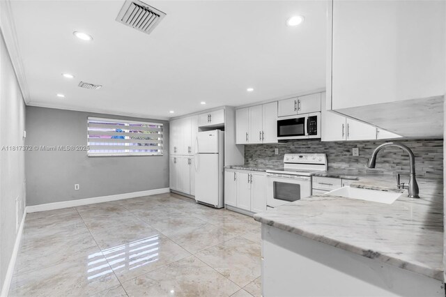810 E 9th Pl, Hialeah, FL 33010 - kitchen featuring white appliances, a sink, white cabinetry, decorative backsplash, and recessed lighting