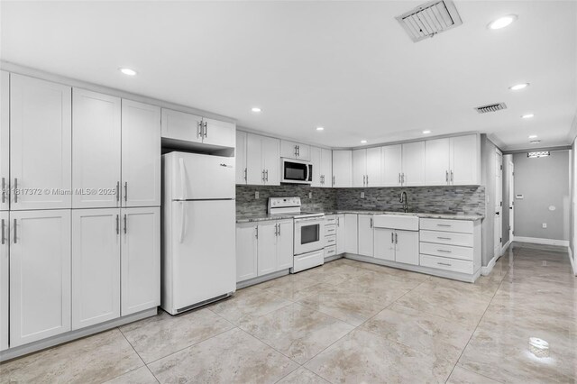 810 E 9th Pl, Hialeah, FL 33010 - kitchen with white appliances, white cabinets, decorative backsplash, light stone counters, and recessed lighting