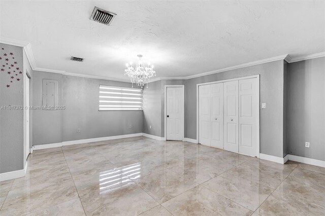 810 E 9th Pl, Hialeah, FL 33010 - unfurnished bedroom with ornamental molding, a chandelier, multiple closets, and baseboards
