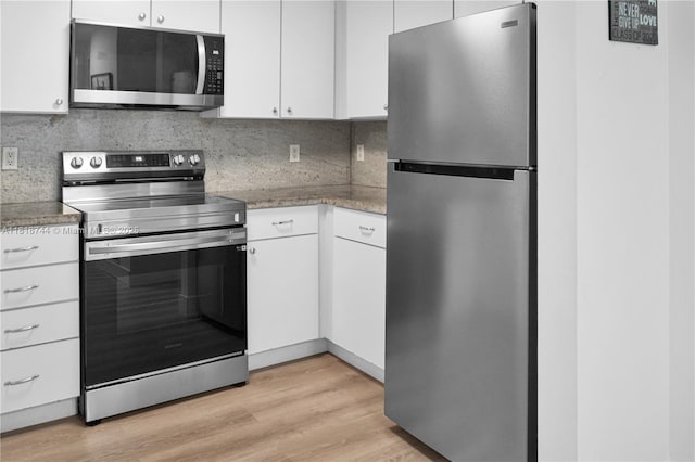1250 S Miami Ave Unit 2310, Miami, FL 33130 - kitchen with appliances with stainless steel finishes, white cabinetry, light wood-style floors, and decorative backsplash