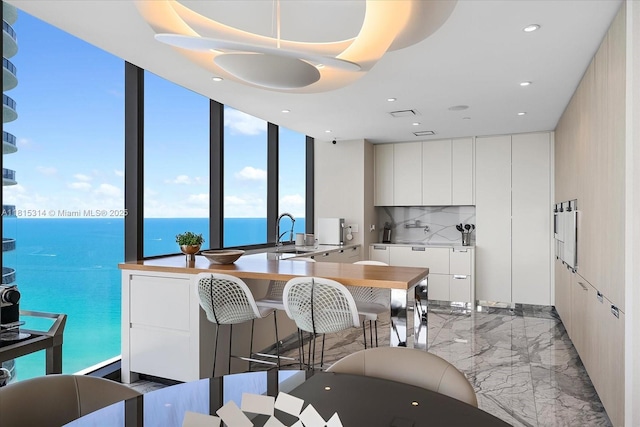 15701 Collins Ave Unit 3101, Sunny Isles Beach, FL 33160 - kitchen with light marble finish flooring, modern cabinets, white cabinets, a sink, and recessed lighting