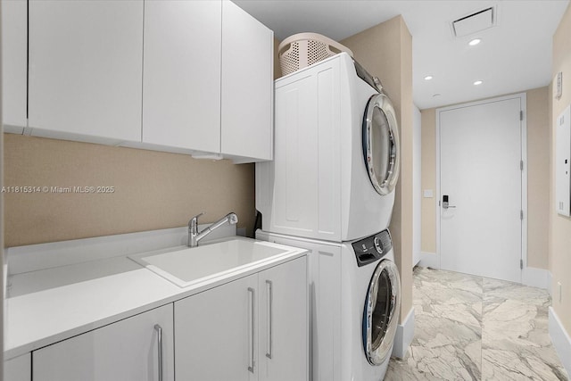 15701 Collins Ave Unit 3101, Sunny Isles Beach, FL 33160 - washroom featuring stacked washer and clothes dryer, cabinet space, light marble finish flooring, recessed lighting, and baseboards