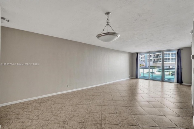 3001 S Ocean Dr Unit 247, Hollywood, FL 33019 - tiled spare room featuring a wall of windows, baseboards, and a textured ceiling