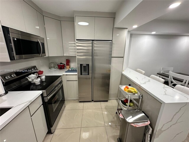 1140 Independence Trl Unit 1140-J, Homestead, FL 33034 - kitchen featuring appliances with stainless steel finishes, gray cabinetry, modern cabinets, light stone counters, and recessed lighting