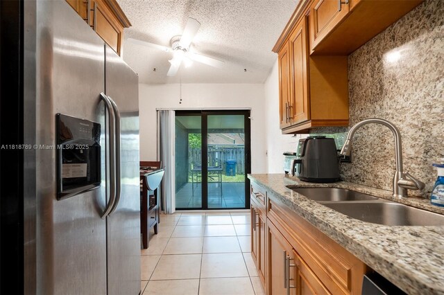 7382 NW 34th St, Lauderhill, FL 33319 - kitchen with stainless steel fridge with ice dispenser, a sink, brown cabinetry, ceiling fan, and light tile patterned floors