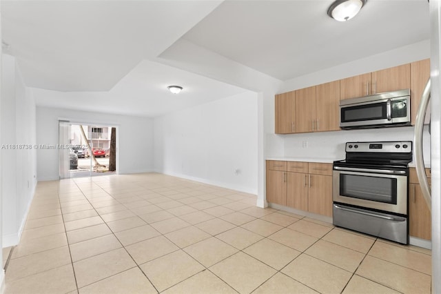 2660 W 76th St Unit 106, Hialeah, FL 33016 - kitchen featuring appliances with stainless steel finishes, light countertops, open floor plan, light tile patterned flooring, and baseboards
