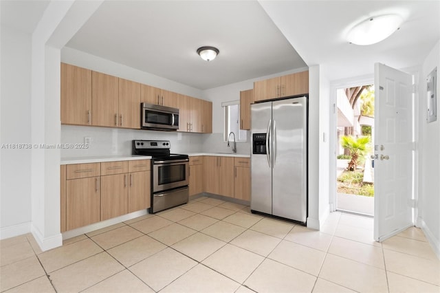 2660 W 76th St Unit 106, Hialeah, FL 33016 - kitchen with appliances with stainless steel finishes, light countertops, a sink, baseboards, and light tile patterned floors