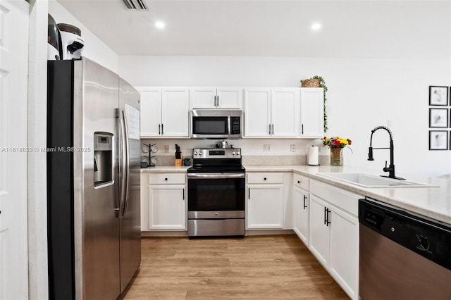 9362 W 33rd Ln, Hialeah, FL 33018 - kitchen featuring appliances with stainless steel finishes, a sink, white cabinetry, light countertops, and recessed lighting